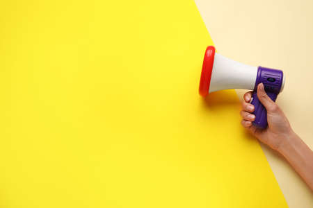 Woman with toy megaphone on color backgroundの写真素材