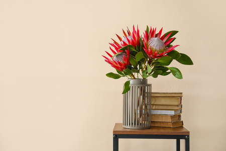 Table with protea flowers and books near color wallの写真素材