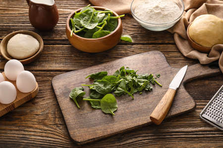 Ingredients for preparing spinach tart on wooden backgroundの写真素材