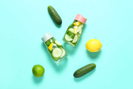Bottles with cucumber lemonade on color backgroundの写真素材