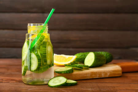 Bottle with cucumber lemonade on wooden backgroundの写真素材