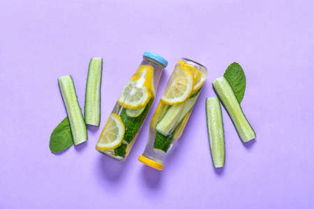 Bottles with cucumber lemonade on color backgroundの写真素材
