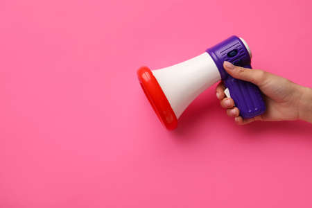 Woman with toy megaphone on color backgroundの写真素材