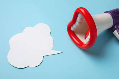 Toy megaphone and speech bubble on color backgroundの写真素材