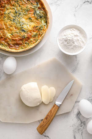Spinach tart and ingredients on light backgroundの写真素材