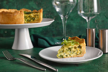 Tasty spinach tart and glasses on color background