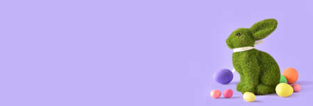 Cute Easter bunny and eggs on color background with space for textの写真素材