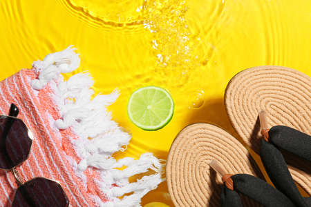 Beach accessories in water on color background, closeup