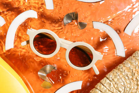 Summer composition with female accessories and slices of coconut on color background with water...