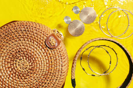 Stylish accessories and bag in water on color background