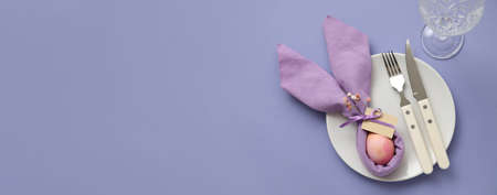 Beautiful table setting for Easter celebration on purple background with space for text