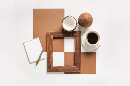Composition with empty picture frame, cards, notebook and cup of coffee on white background