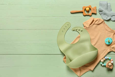 Baby clothes, toys and accessories on color wooden backgroundの写真素材
