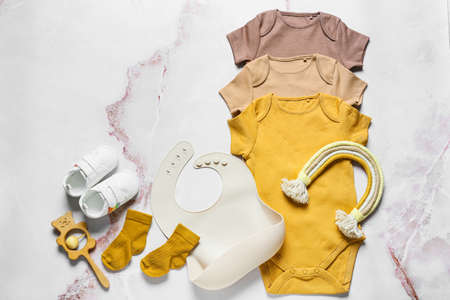 Composition with baby clothes, bib, toys and shoes on light backgroundの写真素材