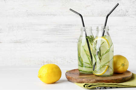 Bottles with cucumber lemonade on light wooden backgroundの写真素材