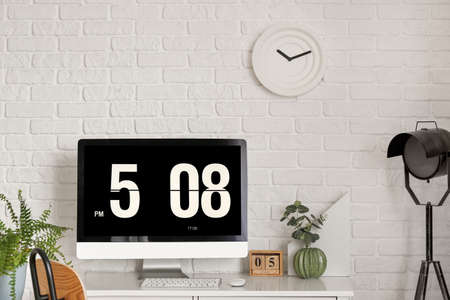 Modern workplace with computer near brick wallの写真素材