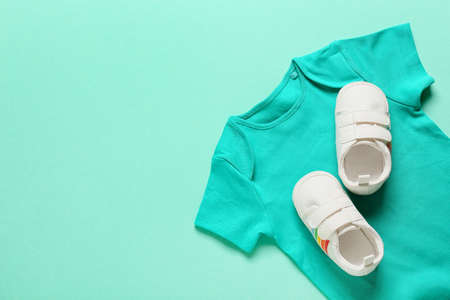 Baby clothes and shoes on color backgroundの写真素材