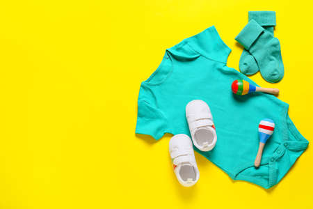 Baby clothes, shoes and toys on color backgroundの写真素材