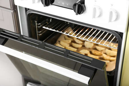 Electric oven with potato in kitchen, closeup