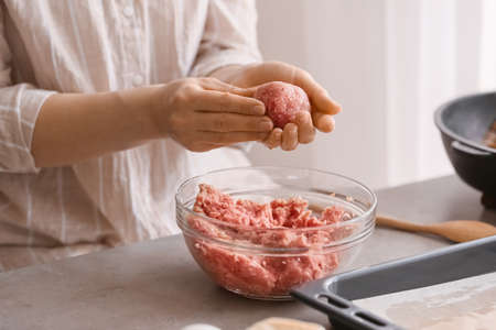 Woman preparing tasty cutlets in the kitchenの写真素材