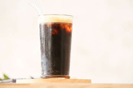 Glass of tasty iced coffee on table