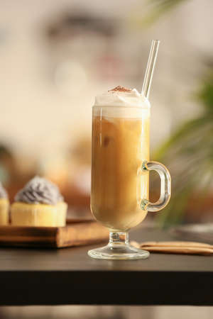 Glass of tasty iced coffee on table