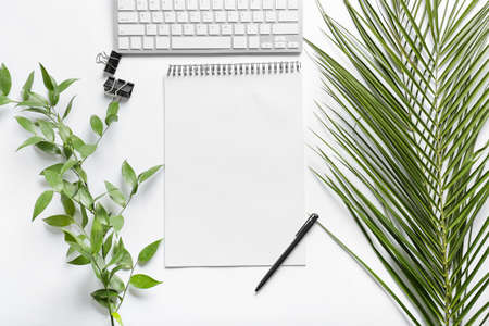 Composition with blank notebook, pen and palm leaves on white background