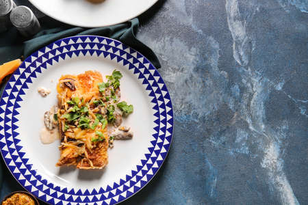 Plate with piece of delicious casserole with minced meat on color background