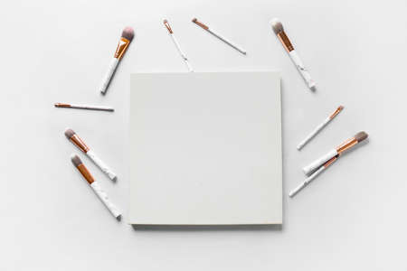 Blank poster and makeup brushes on light backgroundの写真素材