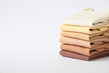 Stack of baby clothes on gray background