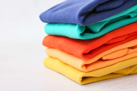 Stack of baby clothes on light background, closeupの写真素材