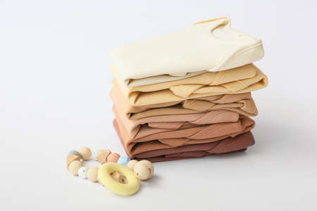 Stack of baby clothes and teether on gray backgroundの写真素材