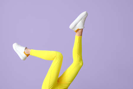 Legs of sporty young woman in leggings on color backgroundの写真素材