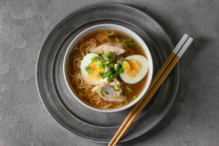 Tasty Chinese soup with chicken in bowl on dark background