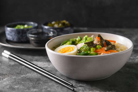 Tasty Chinese soup with chicken in bowl on dark backgroundの写真素材