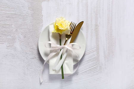 Beautiful table setting with narcissus flower on light background