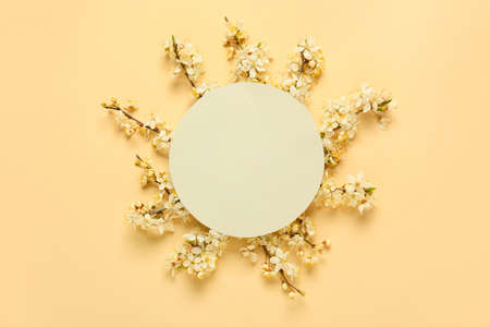 Beautiful blooming branches and blank card on color backgroundの写真素材