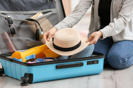 Woman packing suitcase at home