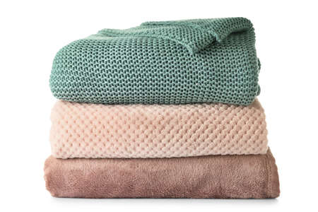 Soft folded blankets on white background