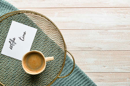 Tray with cup of coffee and sheet of paper with text COFFEE TIME on wooden background