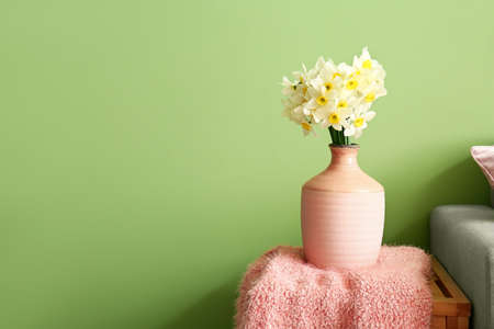 Vase with narcissus flowers in the roomの写真素材