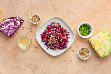 Plate with tasty cabbage salad and ingredients on color backgroundの写真素材
