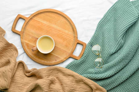 Wooden tray with cup of coffee and glasses on fabric backgroundの写真素材