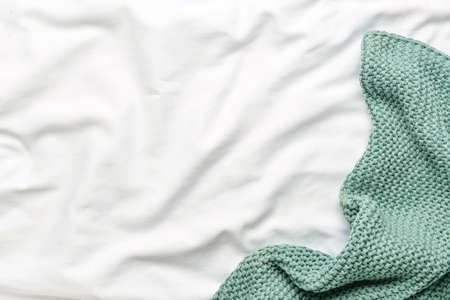 Crumpled knitted blanket on white fabric backgroundの写真素材