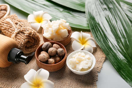 Bowl of shea butter, nuts and bath supplies on table, closeupの写真素材
