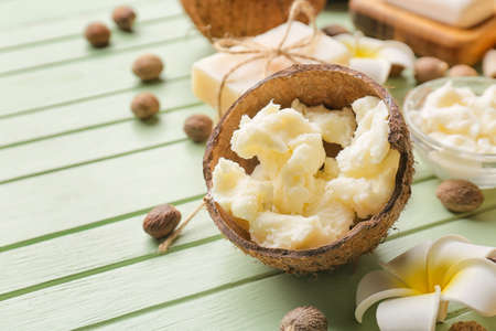 Coconut shell with shea butter on color wooden backgroundの写真素材