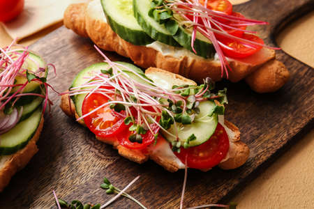 Tasty croissants with vegetables and micro green on color background, closeupの写真素材