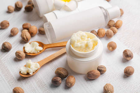 Jar of shea butter, nuts and cosmetic products on light background, closeupの写真素材