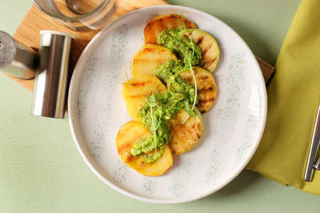Tasty grilled vegetables with pesto sauce on color wooden backgroundの写真素材