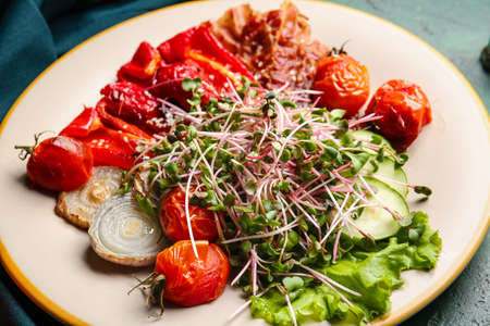 Plate of tasty salad with vegetables, fried bacon and micro green, closeupの写真素材